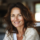 Femme souriante avec cheveux châtains ondulés.